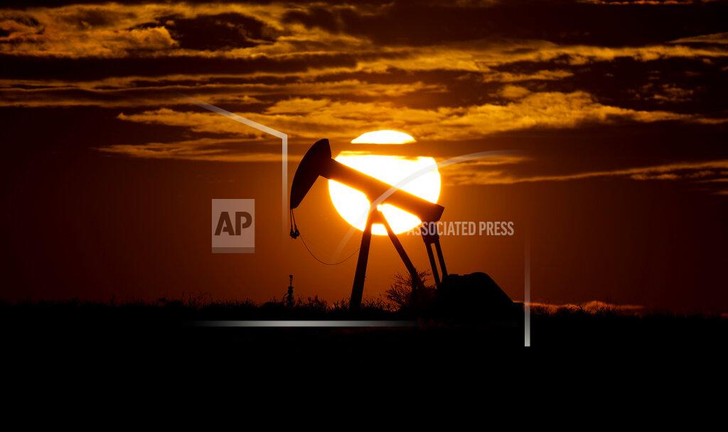 Eric Gay FILE - In this Wednesday, April 8, 2020, file photo, the sun sets behind an idle pump jack near Karnes City, Texas. In 2020, the coronavirus pandemic created winners and losers in the business world. The oil industry was pummeled after travel was halted in efforts to contain the coronavirus, sending demand for jet fuel and gasoline plummeting. (AP Photo/Eric Gay, File)