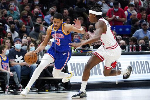Golden State Warriors guard Jordan Poole, left, drives against Chicago Bulls guard Ayo Dosunmu during the first half of an NBA basketball game in Chicago, Friday, Jan. 14, 2022. (AP Photo/Nam Y. Huh)