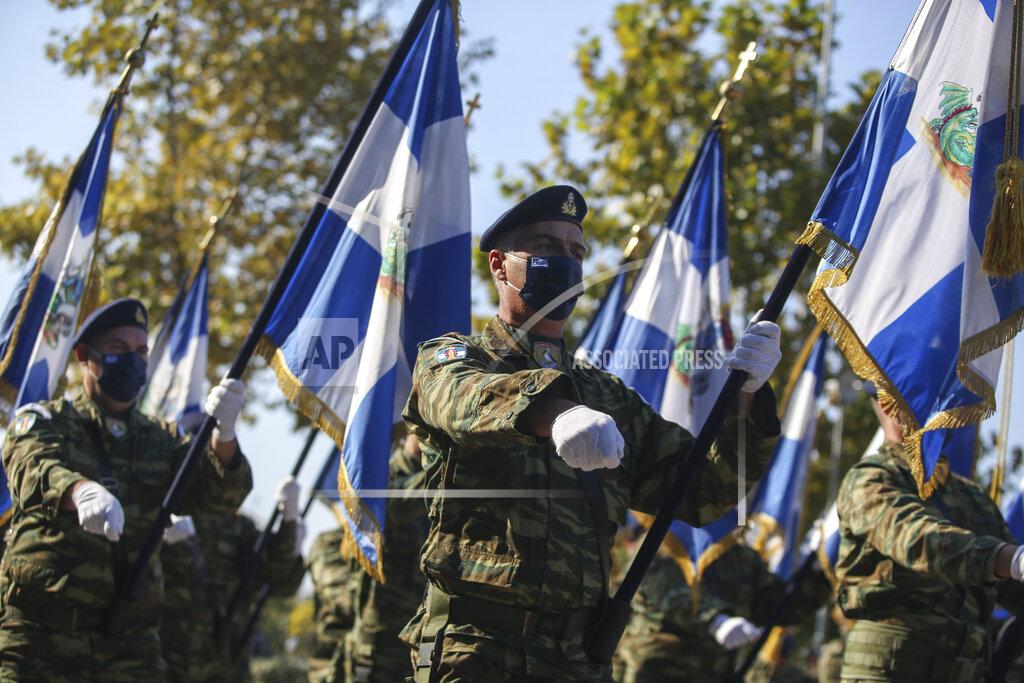 Giannis Papanikos Greek soldiers hold Greek flags during a military parade at the northern port city of Thessaloniki, Greece, Thursday, Oct. 28, 2021 .The parade is held to celebrate Greece's refusal to align itself with a belligerent fascist Italy in 1940 and instead fight a much stronger opponent, a decision which dragged it into World War II and eventually led to a brutal occupation by Nazi Germany. (AP Photo/Giannis Papanikos)