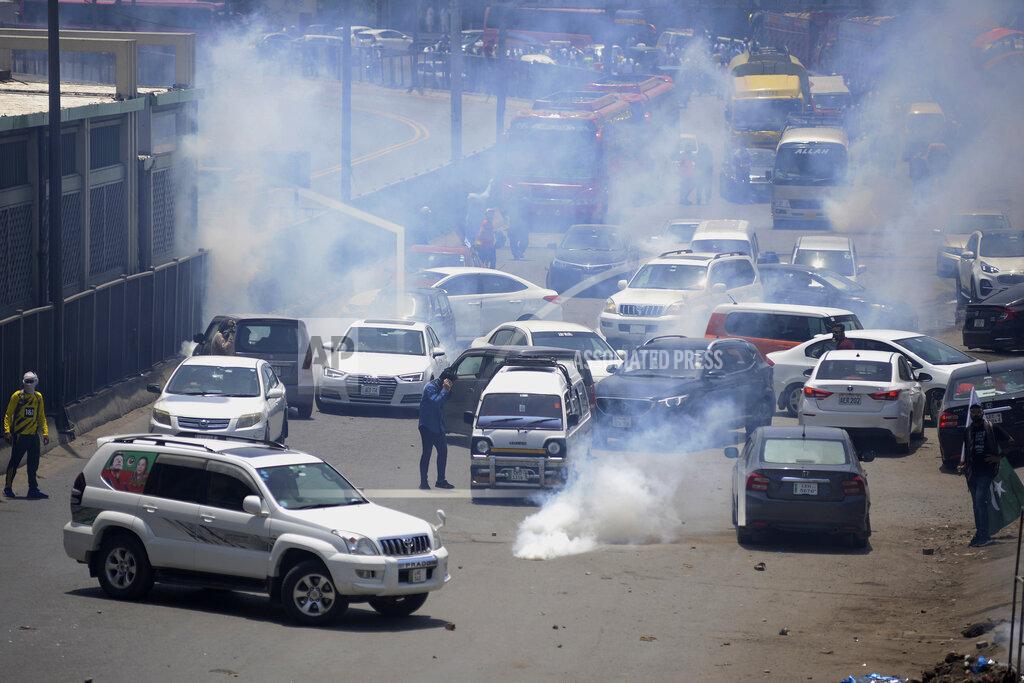 K.M. Chaudary Police fire tear gas to disperse supporters of Pakistan's key opposition party marching toward Islamabad, in Lahore, Pakistan, Wednesday, May 25, 2022. Pakistani authorities blocked off all major roads into the capital Islamabad on Wednesday, after a defiant former Prime Minister Imran Khan said he would march with demonstrators to the city center for a rally he hopes will bring down the government and force early elections. (AP Photo/K.M. Chaudary)