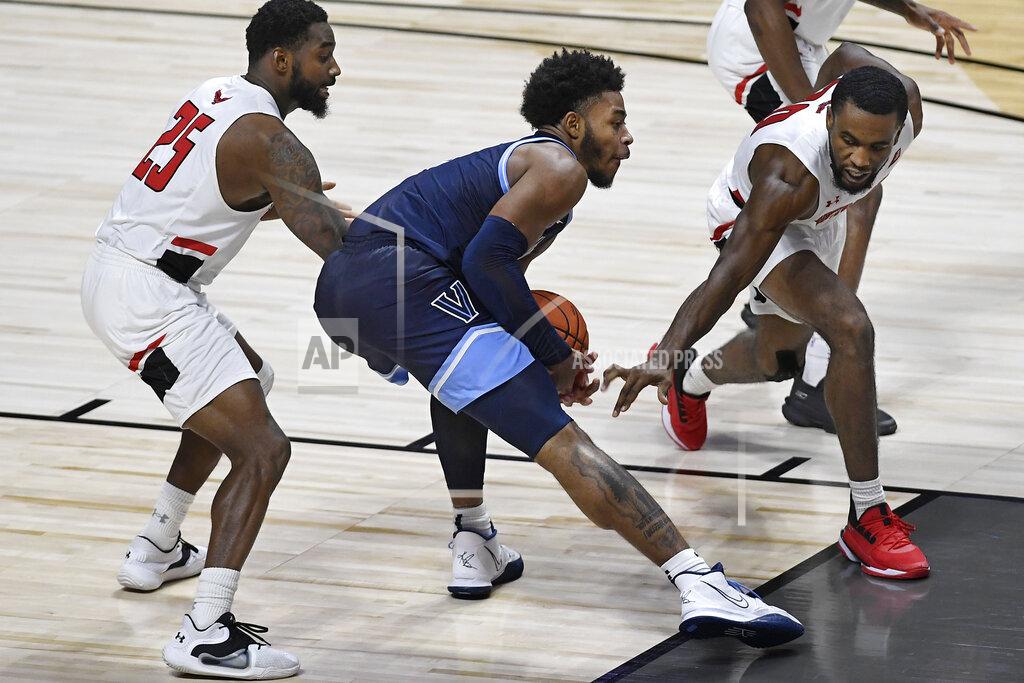 Jessica Hill Villanova's Justin Moore, center, keeps the ball from Hartford's Traci Carter, left, and Austin Williams, right, in the second half of an NCAA college basketball game Tuesday, Dec. 1, 2020, in Uncasville, Conn. (AP Photo/Jessica Hill)
