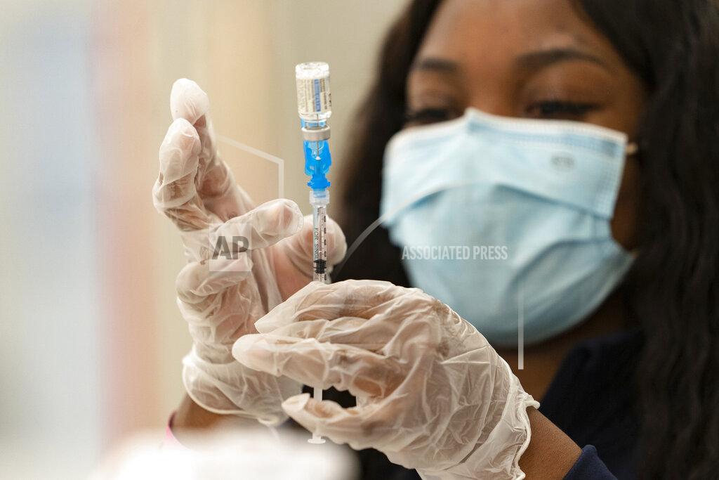 FILE - In this Thursday, March 11, 2021, file photo, a health worker loads syringes with the vaccine on the first day of the Johnson & Johnson vaccine being made available to residents at the Baldwin Hills Crenshaw Plaza in Los Angeles. California officials say much of the state will be able to reopen next week to indoor activities as coronavirus case rates remain low. At the same time, more than 4 million residents with certain disabilities or health concerns become eligible for a vaccine. (AP Photo/Damian Dovarganes, File)