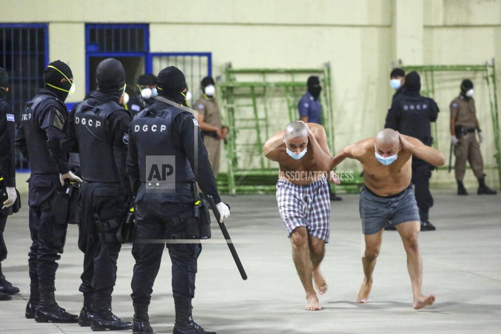 Uncredited In this photo released by El Salvador Presidency Press Office police wearing masks as precautions against the new coronavirus guard inmates, also wearing masks, during a security operation after President Nayib Bukele decreed maximum emergency in prisons housing gang members at the Izalco prison in San Salvador, El Salvador, Saturday, April 25, 2020. Bukele ordered the emergency the day after more than twenty people were killed throughout country that authorities said were ordered from prisons. (El Salvador President Press Office via AP)