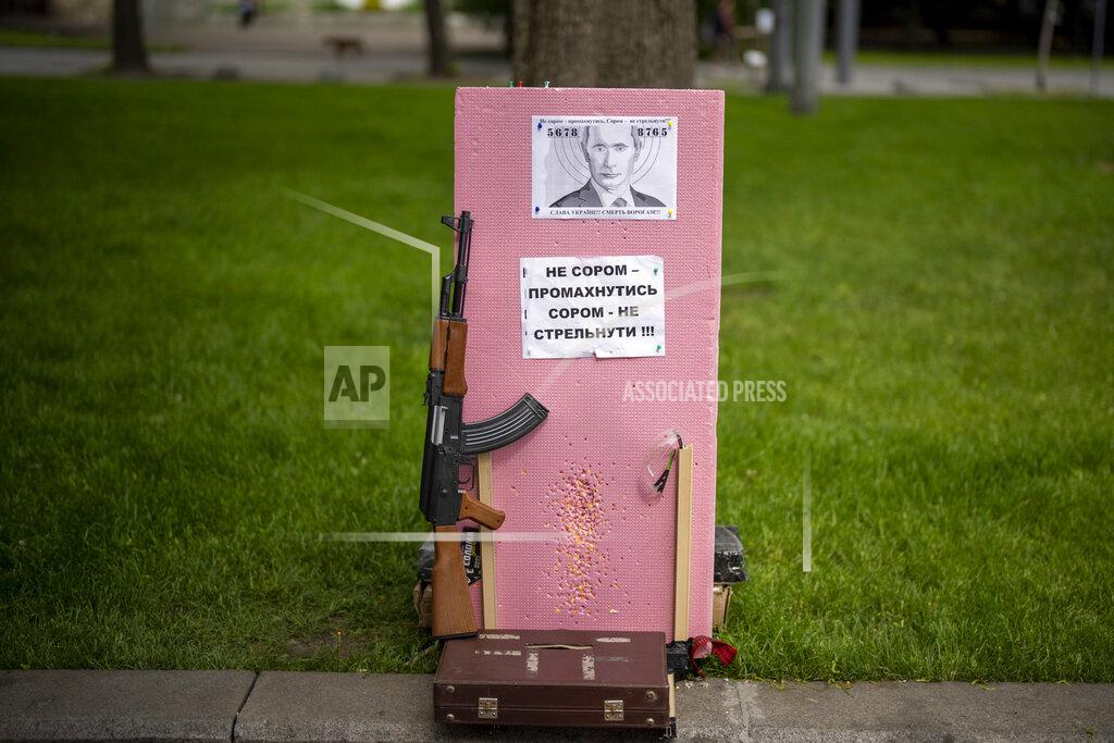 Emilio Morenatti A plastic Kalashnikov rifle to shoot balls at a portrait of Russian President Vladimir Putin, is photographed at a street attraction in the centre of Lviv, Ukraine on Saturday, May 14, 2022. The banner reads in Ukrainian: It's not a shame to miss. It's a shame not to try to shoot! Glory to Ukraine, Death to our enemies!. (AP Photo/Emilio Morenatti)