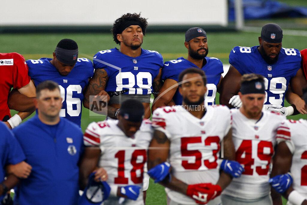 Adam Hunger New York Giants tight end Evan Engram (88) and Saquon Barkley (26) stand with linked arms with teammates to make a social injustice statement prior to their scrimmage at the NFL football team's training camp in East Rutherford, N.J., Friday, Aug. 28, 2020. (AP Photo/Adam Hunger)