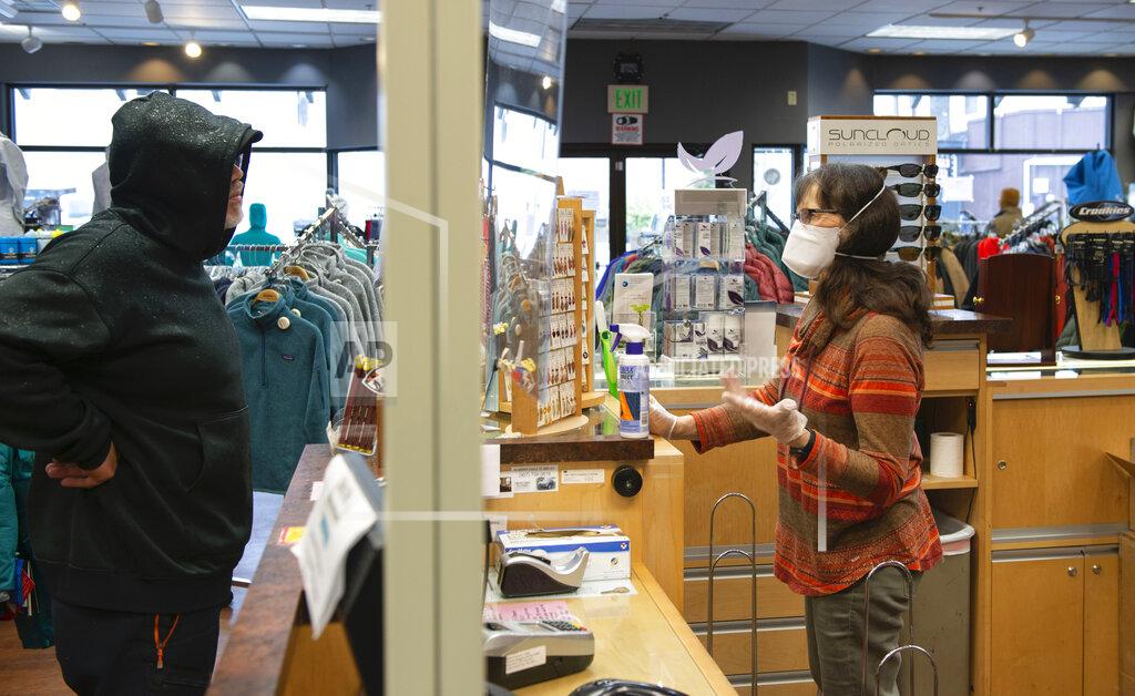 James Poulson Marsha Howard, right, helps Jason Gjertsen at the Work & Rugged Gear Store in Sitka, Alaska, Friday, April 24, 2020. Howard has been following state recommendations by encouraging customers to phone in orders and by allowing only three people at a time inside the store, using face masks and using disinfectants on surfaces. (James Poulson/The Daily Sitka Sentinel via AP)