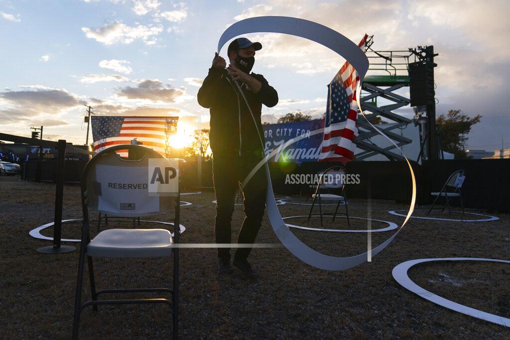Carolyn Kaster FILE - In this Oct. 16, 2020, file photo a worker places social distancing circles around chairs before Democratic presidential candidate former Vice President Joe Biden arrives to speak at Michigan State Fairgrounds in Novi, Mich.. (AP Photo/Carolyn Kaster, File)
