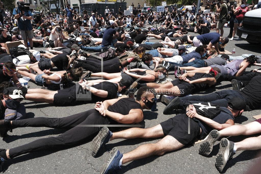 Richard Vogel LGBTQ community members join Black Lives Matter demonstrators lie face down depicting George Floyd during his detention by police, blocking an intersection in protest over Floyd's death, in West Hollywood, Calif., on Wednesday, June 3, 2020. Floyd, an African American, died on May 25 after a white Minneapolis police officer pressed a knee into his neck for several minutes even after he stopped moving and pleading for air. (AP Photo/Richard Vogel)