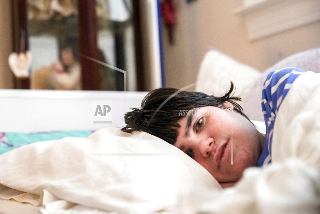 Sophia Germer Lauren, the daughter of Sue Roesky who has cerebral palsy and is non-verbal, lies in bed at their home in Metairie, La., Friday, Sept. 17, 2021. (Sophia Germer/The Times-Picayune/The New Orleans Advocate via AP)