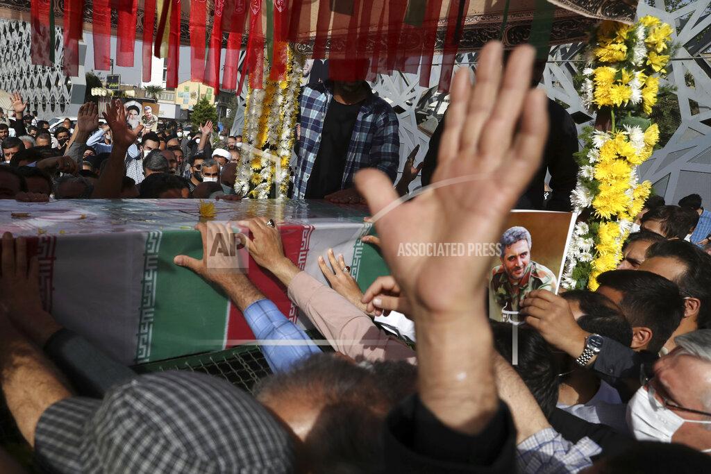 Vahid Salemi People mourn next to the flag draped coffin of Iran's Revolutionary Guard Col. Hassan Sayyad Khodaei who was killed on Sunday, in his funeral ceremony in Tehran, Iran, Tuesday, May 24, 2022. Iran's hard-line President Ebrahim Raisi vowed revenge on Monday over the killing of Sayyad Khodaei who was shot at his car by two assailants outside his home in Tehran, a still-mysterious attack on the country's powerful paramilitary force. (AP Photo/Vahid Salemi)