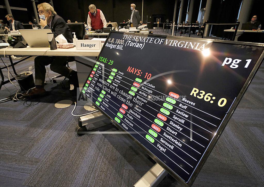 The budget bill, HB1800 was approved by a vote of 29-10 during the floor session of the Virginia Senate, which is meeting inside the Science Museum of Virginia in Richmond, Va., Saturday, Feb. 27, 2021. (Bob Brown/Richmond Times-Dispatch via AP)
