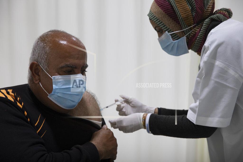 Ariel Schalit Mohamed Agbariyah receives a coronavirus vaccine at a COVID-19 vaccination center in the northern Arab Israeli town of Umm el-Fahm, Israel, Tuesday, Jan. 5, 2021. With elections approaching in March, Israeli Prime Minister Benjamin Netanyahu has placed his world-leading vaccination drive at the center of his re-election campaign launching an aggressive media blitz portraying him as almost singlehandedly leading the country out of the pandemic. (AP Photo/Ariel Schalit)