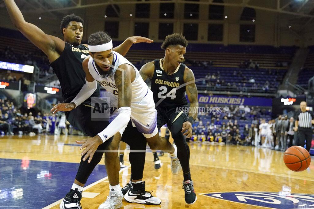 Ted S. Warren Washington guard PJ Fuller, center, eyes the ball as he dives out of bounds between Colorado guards KJ Simpson, left, and Elijah Parquet (24) during the first half of an NCAA college basketball game, Thursday, Jan. 27, 2022, in Seattle. (AP Photo/Ted S. Warren)