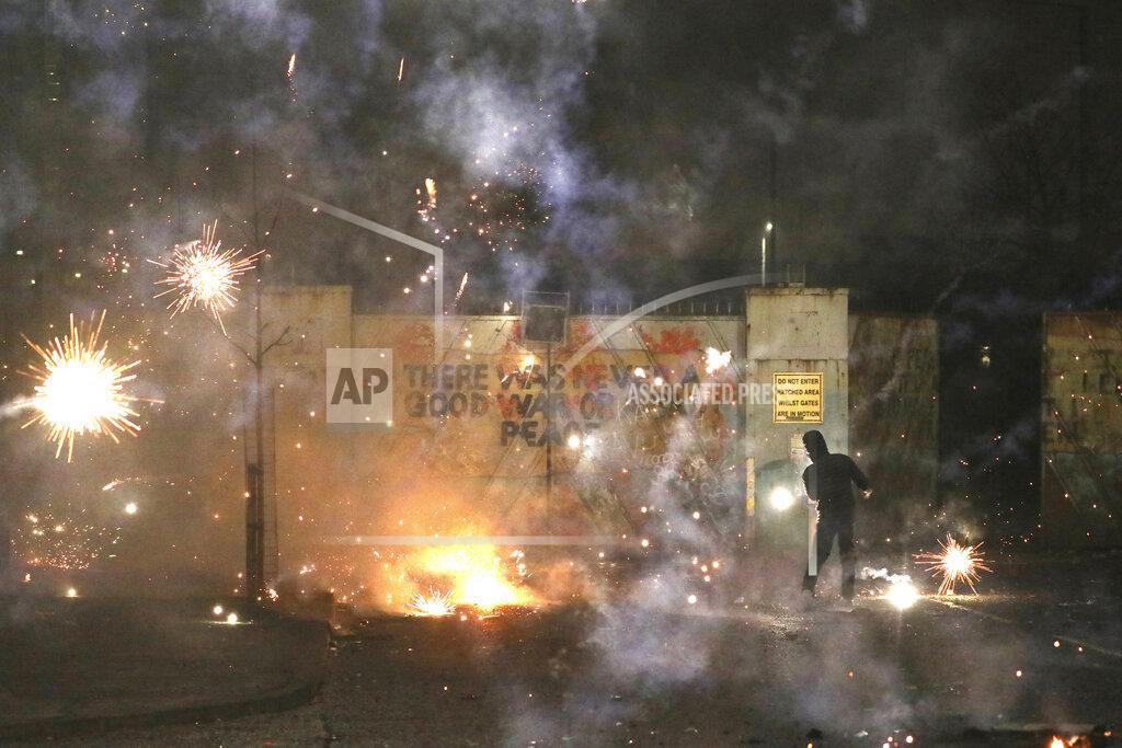Peter Morrison FILE - In this Wednesday, April 7, 2021 file photo, a firework explodes as Nationalist and Loyalist rioters clash with one another at the peace wall on Lanark Way in West Belfast, Northern Ireland. The chaotic scenes during a week of violence on the streets of Northern Ireland have stirred memories of decades of Catholic-Protestant conflict, known as “The Troubles.” A 1998 peace deal ended large-scale violence but did not resolve Northern Ireland’s deep-rooted tensions. (AP Photo/Peter Morrison, File)