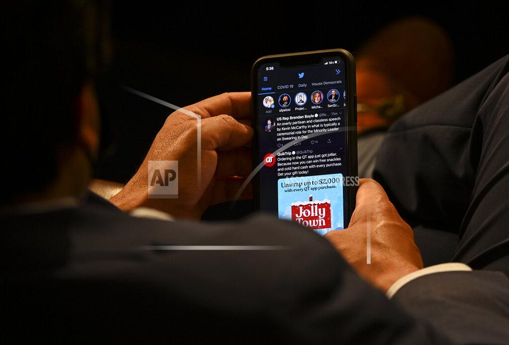 Bill O'leary A House member checks his phone on opening day of the 117th Congress at the U.S. Capitol in Washington, Sunday, Jan. 3, 2021. (Bill O'Leary/The Washington Post via AP, Pool)