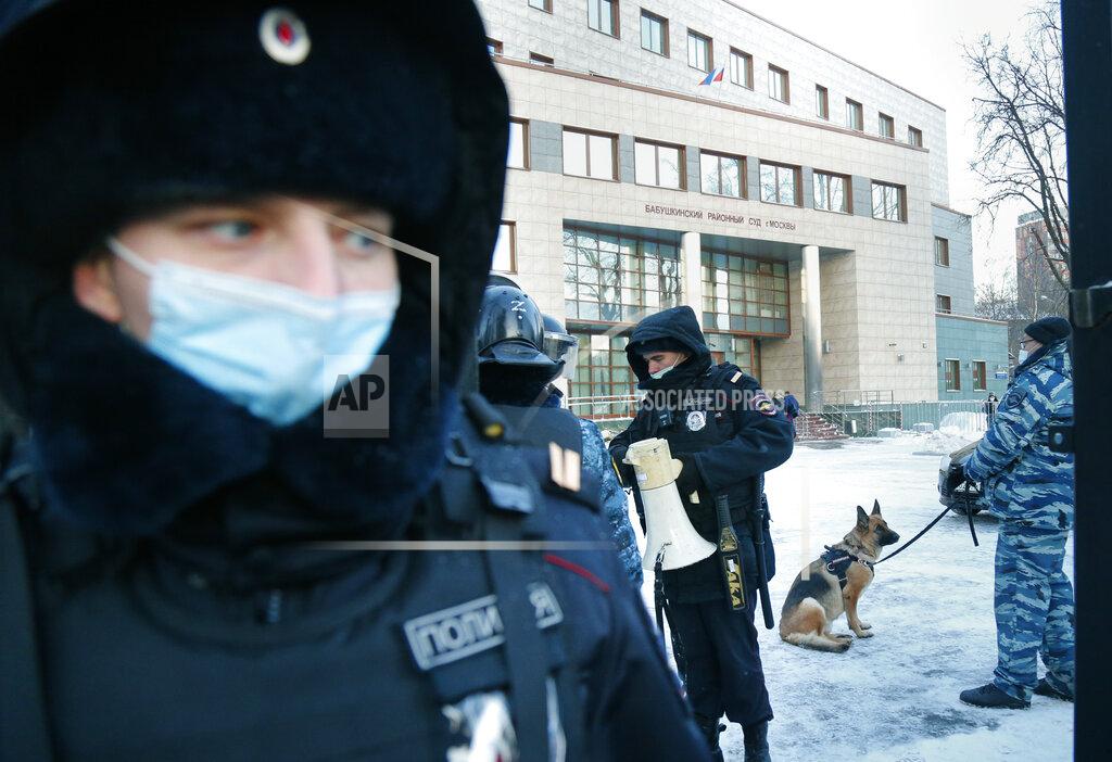 Alexander Zemlianichenko Policemen stand guard at the Babuskinsky district court prior to the continuation of the trial against Russian opposition leader Alexey Navalny in Moscow, Russia, Friday, Feb. 5, 2021. Navalny was accused of slandering a World War II veteran featured in the video promoting the constitutional reform allowing to extend President Vladimir Putin's rule. The politician slammed people in the video as "corrupt stooges" and "traitors." (AP Photo/Alexander Zemlianichenko)