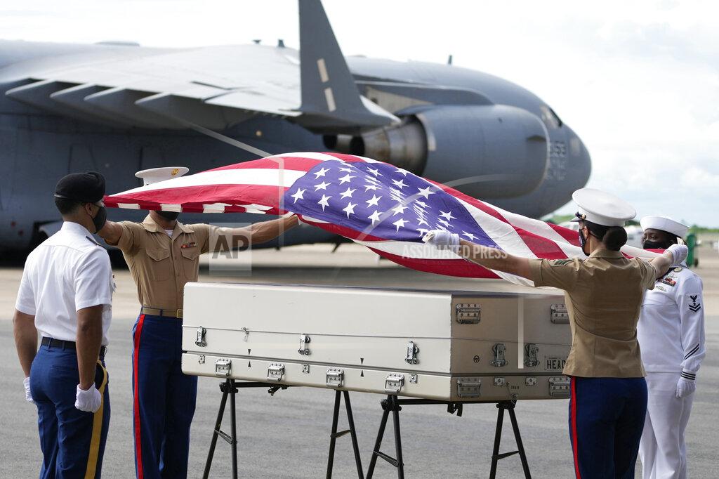 Sakchai Lalit U.S. military drape a national flag over the possible remains of a WWII U.S. airman found in northern Thailand, during a repatriation ceremony Wednesday, May 18, 2022, at the U-Tapao Air Base in Rayong province, eastern Thailand. The possible human remains were found at a crash site in a rice field in northern Thailand by the Defense POW/MIA Accounting Agency and were sent to Hawaii where they will be tested to see if they belong to a U.S. pilot who went missing in 1944. (AP Photo/Sakchai Lalit)