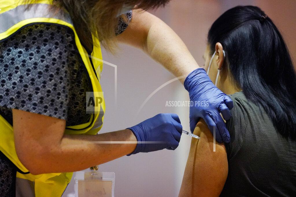 Kathy Willens FILE - In this Tuesday, Jan. 5, 2021, file photo, a woman receives a dose of the COVID-19 vaccine from a pharmacist at Nassau County's first vaccination distribution site, set up by Northwell Health and Nassau County, at Nassau County Community College, in Garden City, N.Y. Vaccine passports being developed to verify COVID-19 immunization status and allow inoculated people to more freely travel, shop and dine have become the latest flash point in America’s perpetual political wars. (AP Photo/Kathy Willens, File)