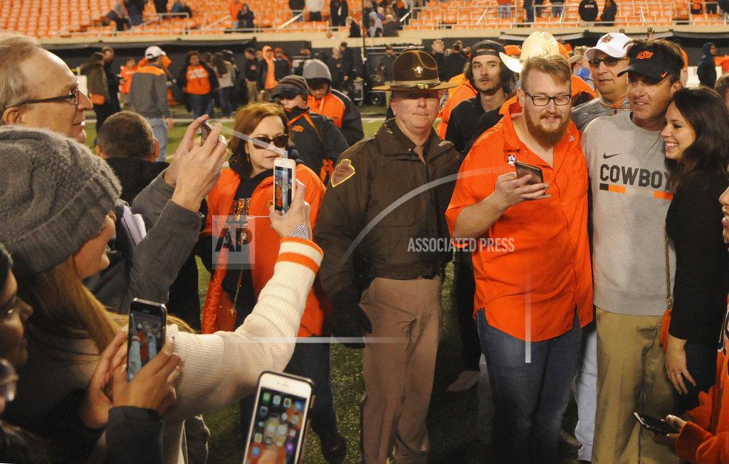 Brody Schmidt Oklahoma State head coach Mike Gundy celebrates with fans following the 45-41 upset over West Virginia at the end of an NCAA college football game in Stillwater, Okla., Saturday, Nov. 17, 2018. (AP Photo/Brody Schmidt)