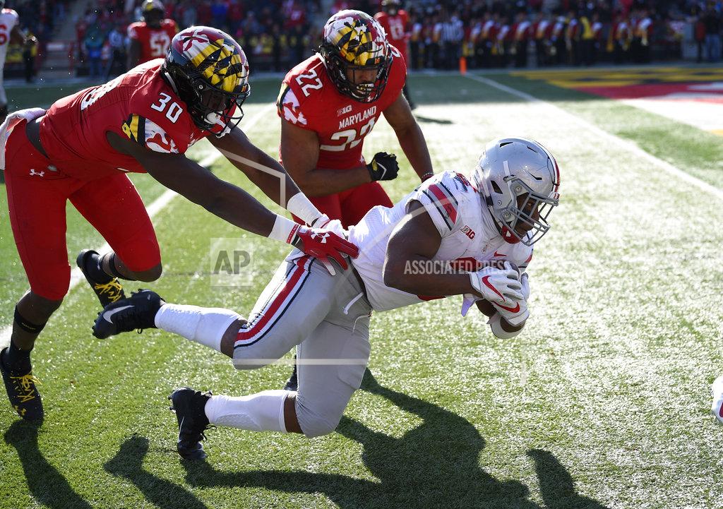 Nick Wass Ohio State running back J.K. Dobbins, front, dives for yardage against Maryland linebacker Isaiah Davis (22) and linebacker Durell Nchami (30) during the first half of an NCAA football game, Saturday, Nov. 17, 2018, in College Park, Md. (AP Photo/Nick Wass)