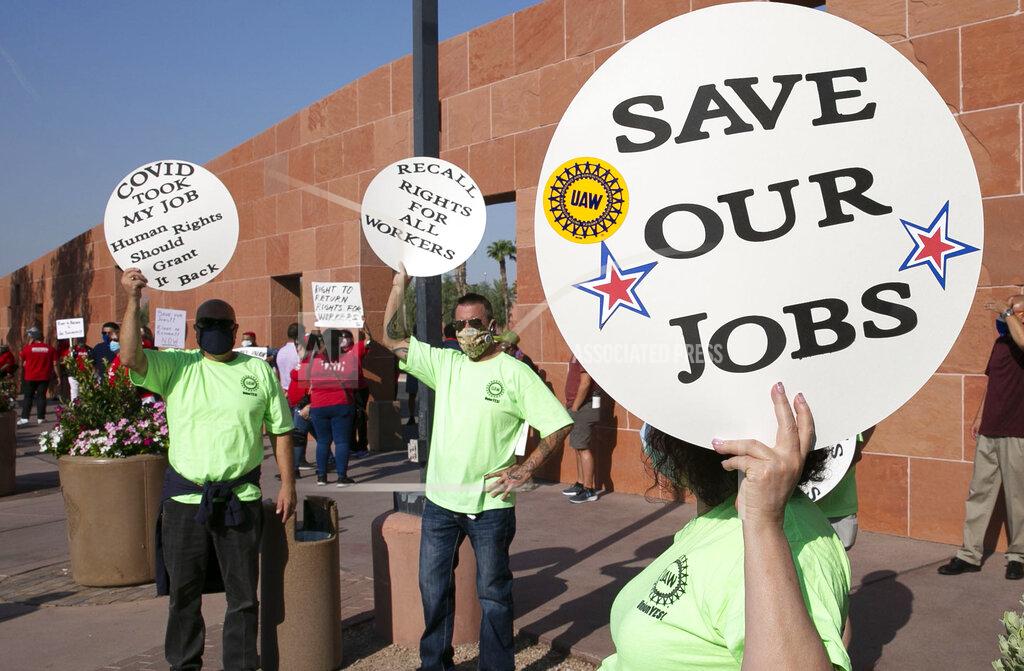 Bizuayehu Tesfaye FILE - In this Aug. 18, 2020 file photo Alex Santana, left, Jim Soldate and Donna Blair, right, rally outside of the Clark County Commission Building in Las Vegas. The two largest Las Vegas casino companies have agreed with unions to let tens of thousands of employees keep family health benefits until next March 1. The powerful culinary and bartenders unions announced Monday, Aug. 31, 2020, the pact affects about 36,000 union workers at 22 Las Vegas Strip properties. (Bizuayehu Tesfaye/Las Vegas Review-Journal via AP, File)
