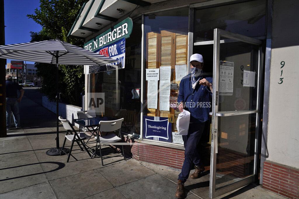 Marcio Jose Sanchez *** Hold For Story *** A costumer exits Pie 'N Burger Tuesday, Dec. 1, 2020, in Pasadena, Calif. Pasadena has become an island in the center of the nation's most populous county, where a surge of COVID-19 cases last week led to a three-week end to outdoor dining and California's first stay-home order since the pandemic began to spread across the state in March. (AP Photo/Marcio Jose Sanchez)