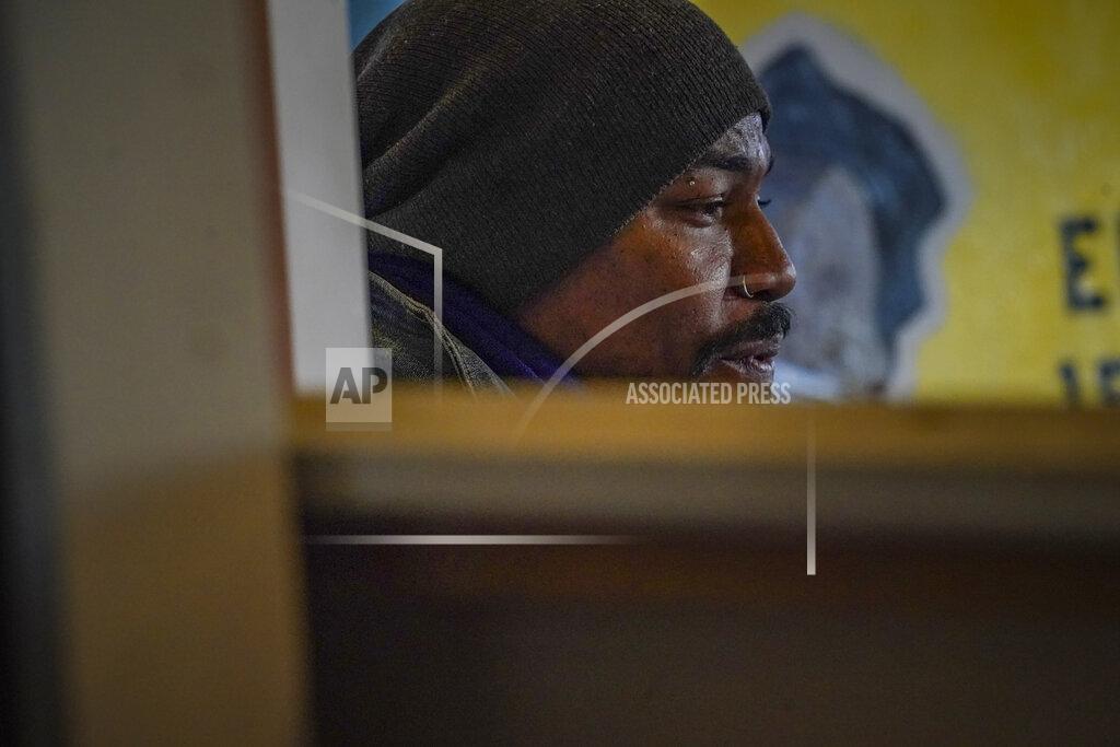 Bebeto Matthews Painter Guy Stanley Philoche, a 43-year-old Haitian immigrant and star in the New York art world, sit among work during an interview at his East Harlem studio, Thursday Nov. 19, 2020, in New York. After a hugely successful gallery show, Philoche wanted to treat himself to a fancy $15,000 watch, instead he bought the works of fellow artists struggling in the pandemic. "I'm not a rich man," he said, "but I owe a big debt to the art world." (AP Photo/Bebeto Matthews)