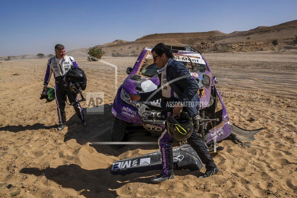 Bernat Armangue In this Tuesday, Jan. 14, 2020 photo, driver Peter Van Merksteijn, of Netherlands, foreground, and co-driver Michael Orr, of Great Britain, after crashing their Toyota during stage nine of the Dakar Rally between Wadi Al Dawasir and Haradth, Saudi Arabia. Formerly known as the Paris-Dakar Rally, the race was created by Thierry Sabine after he got lost in the Libyan desert in 1977. Until 2008, the rallies raced across Africa, but threats in Mauritania led organizers to cancel that year's event and move it to South America. It has now shifted to Saudi Arabia. The race started on Jan. 5 with 560 drivers and co-drivers, some on motorbikes, others in cars or in trucks. Only 41 are taking part in the Original category. (AP Photo/Bernat Armangue)