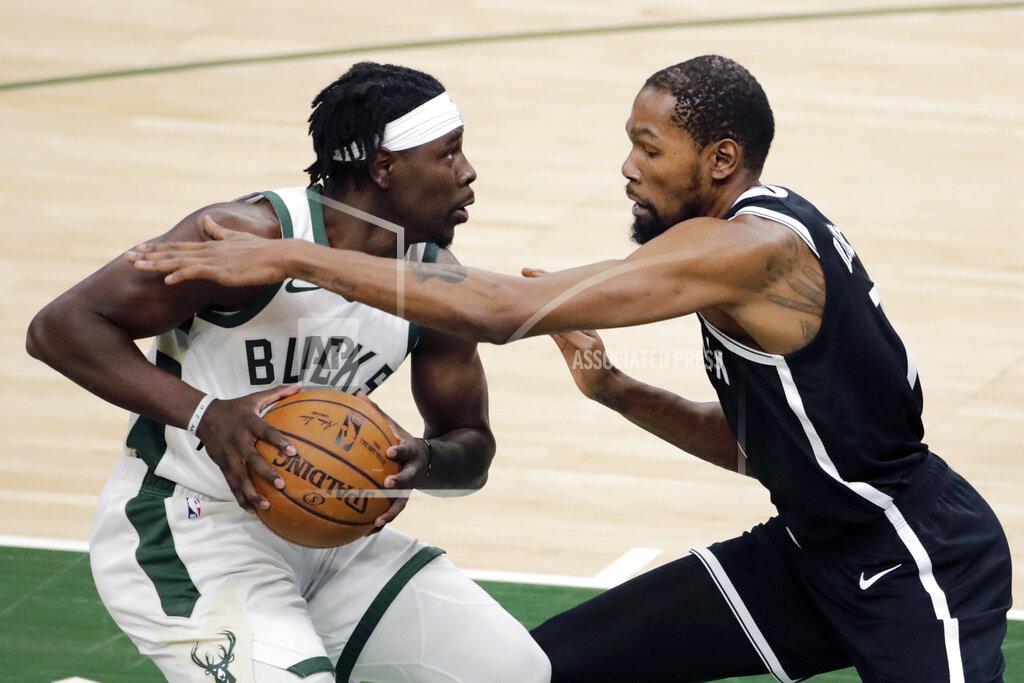 Aaron Gash Milwaukee Bucks' Jrue Holiday, left, drives to the basket against Brooklyn Nets' Kevin Durant during the first half of an NBA basketball game Tuesday, May 4, 2021, in Milwaukee. (AP Photo/Aaron Gash)
