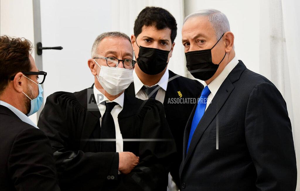 Reuven Castro Israeli Prime Minister Benjamin Netanyahu, right, speaks with his lawyers prior to a hearing at the district court in Jerusalem, Monday, Feb. 8, 2021. Netanyahu appeared in a Jerusalem courtroom Monday to respond formally to corruption charges just weeks before national elections in which he hopes to extend his 12-year rule. (AP Photo/Reuven Castro, Pool)