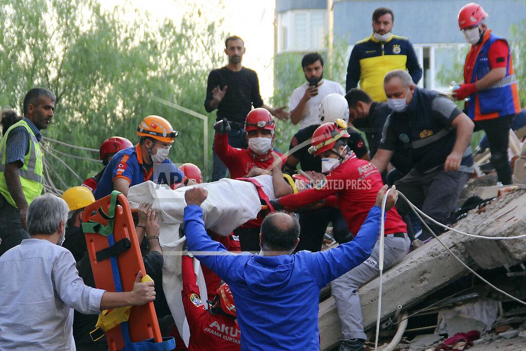 Sadik Cangel Rescuers carry a man rescued from the debris of his collapsed house, in Izmir, Turkey, Friday Oct. 30, 2020. A strong earthquake struck Friday in the Aegean Sea between the Turkish coast and the Greek island of Samos, killing several people and injuring hundreds amid collapsed buildings and flooding. (Sadik Cangel/IHA via AP)