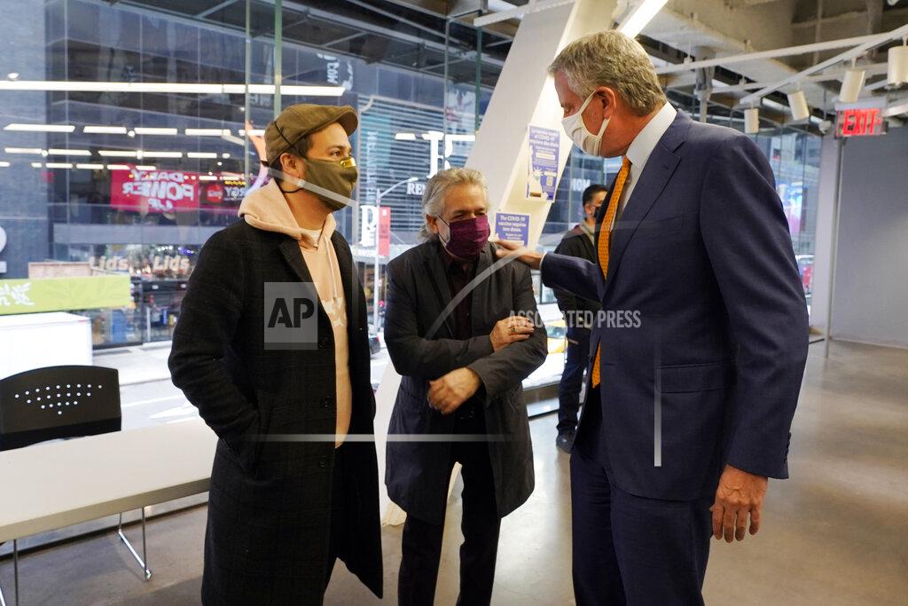 Richard Drew Actor Lin-Manuel Miranda, left, and his father, Luis A. Miranda, Jr., center, talk with New York Mayor Bill de Blasio, before they tour the grand opening of a Broadway COVID-19 vaccination site intended to jump-start the city's entertainment industry, in New York, Monday, April 12, 2021. (AP Photo/Richard Drew, Pool)