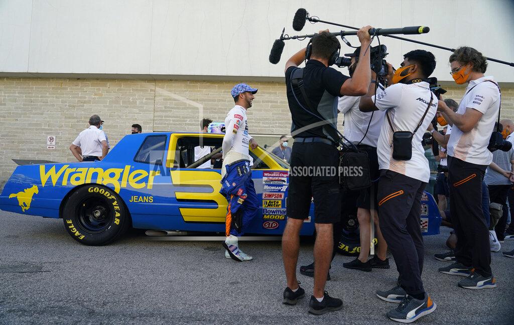Eric Gay McLaren driver Daniel Ricciardo, of Australia, left, talks to media as he prepares to drive the late Dale Earnhardt's iconic 1984 No. 3 Wrangler Chevrolet Monte Carlo before an open practice for the Formula One U.S. Grand Prix auto race at the Circuit of the Americas, Saturday, Oct. 23, 2021, in Austin, Texas. Ricciardo was allowed to drive the car as a reward from his McLaren boss, Zak Brown, for winning his first race with the team. (AP Photo/Eric Gay)