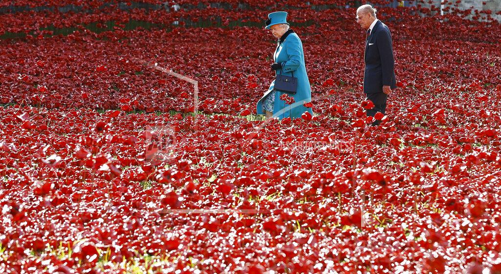 Kirsty Wigglesworth FILE - In this Oct. 16, 2014 file photo Britain's Queen Elizabeth II, left, and Prince Philip walk through the field of ceramic poppies at The Tower of London. The 99-year-old husband of Queen Elizabeth II has been hospitalized after a heart procedure. Prince Philip, the irascible and tough-minded husband of Queen Elizabeth II who spent more than seven decades supporting his wife in a role that both defined and constricted his life, has died, Buckingham Palace said Friday. He was 99. (AP Photo/Kirsty Wigglesworth, File)