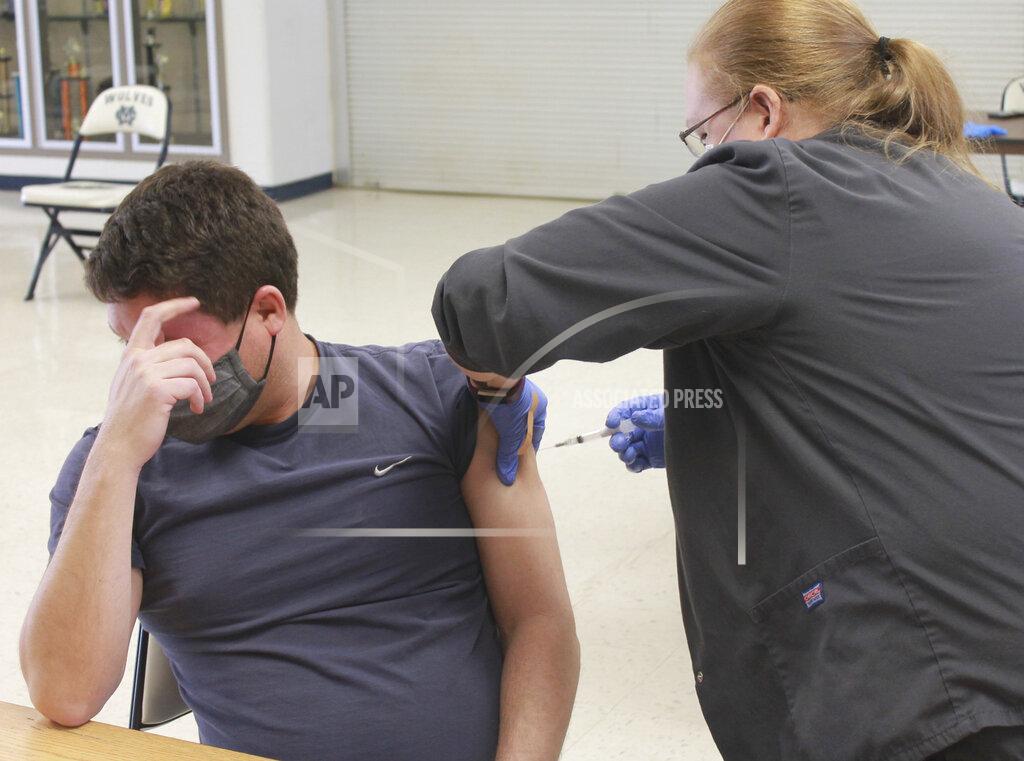 Kelley Smith William Sigler, seventh-grade social studies teacher at Krueger Middle School, looks away as he gets his COVID-19 vaccination Friday, March 12, 2021 at Michigan City High School, thanks to a pop-up clinic hosted by HealthLinc. (Kelley Smith/The News Dispatch via AP)