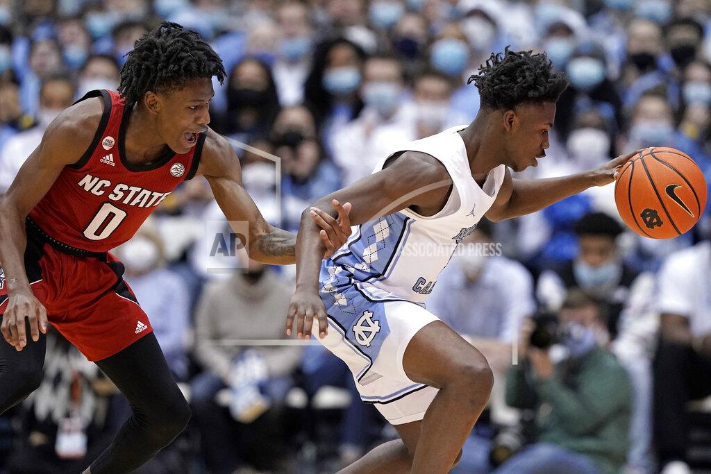 Gerry Broome North Carolina State guard Terquavion Smith (0) reaches for North Carolina guard D'Marco Dunn during the second half of an NCAA college basketball game in Chapel Hill, N.C., Saturday, Jan. 29, 2022. (AP Photo/Gerry Broome)