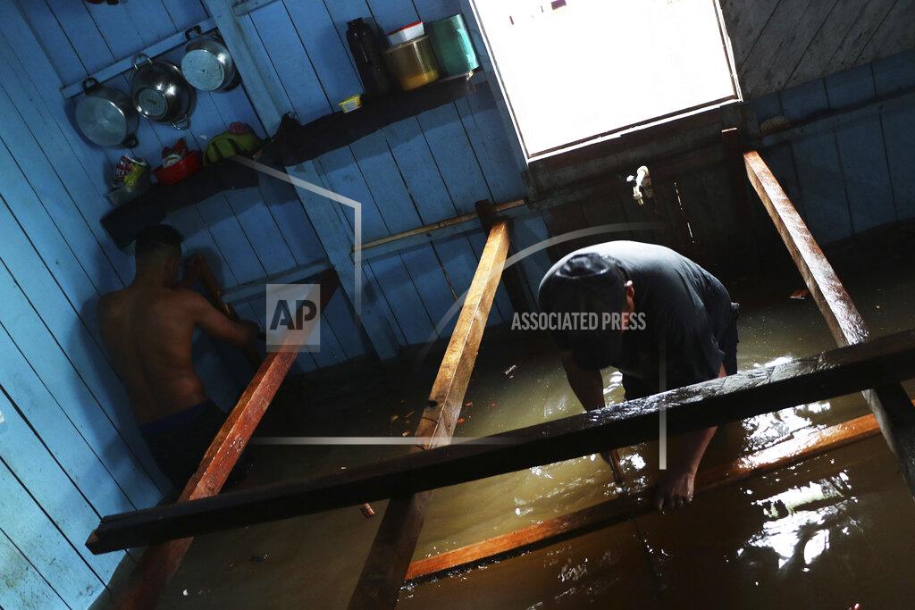 Edmar Barros Residents build raised floors in a flooded home in Anama, Amazonas state, Brazil, Thursday, May 13, 2021. (AP Photo/Edmar Barros)