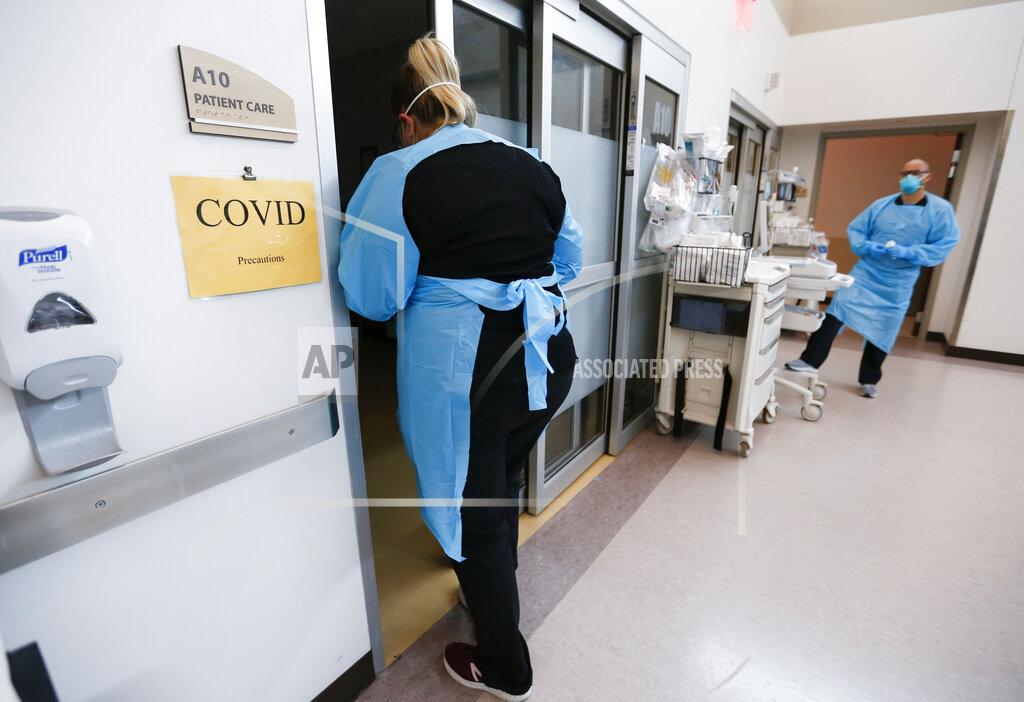 Nathan Papes FILE - In this July 16, 2021 file photo, nurses and doctors in the CoxHealth Emergency Department in Springfield, Mo., don personal protective equipment to treat patients with COVID-19. Across the U.S., the seven-day rolling average for daily new cases in the U.S. rose over the past two weeks on Tuesday, July 21. (Nathan Papes/The Springfield News-Leader via AP)