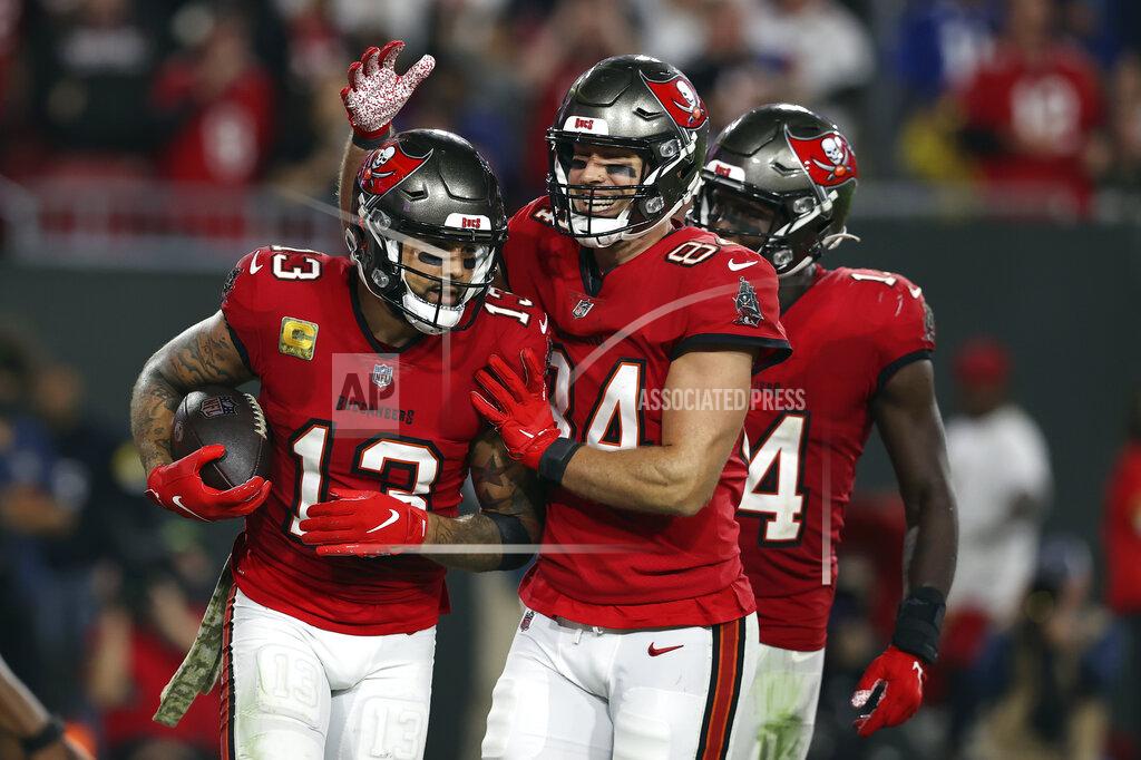 Mark Lomoglio Tampa Bay Buccaneers wide receiver Mike Evans (13) celebrates his 5-yard touchdown reception with tight end Cameron Brate (84) and wide receiver Chris Godwin (14) during the second half of an NFL football game against the New York Giants Monday, Nov. 22, 2021, in Tampa, Fla. (AP Photo/Mark LoMoglio)