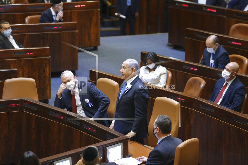 Alex Kolomoisky Israeli Prime Minister Benjamin Netanyahu, center, and Defense Minister Benny Gantz, center left, and other lawmakers attend the swearing-in ceremony for Israel's 24th government, at the Knesset, or parliament, in Jerusalem, Tuesday, April 6, 2021. The ceremony took place shortly after the country's president asked Netanyahu to form a new majority coalition, a difficult task given the deep divisions in the fragmented parliament. (Alex Kolomoisky/Pool via AP)