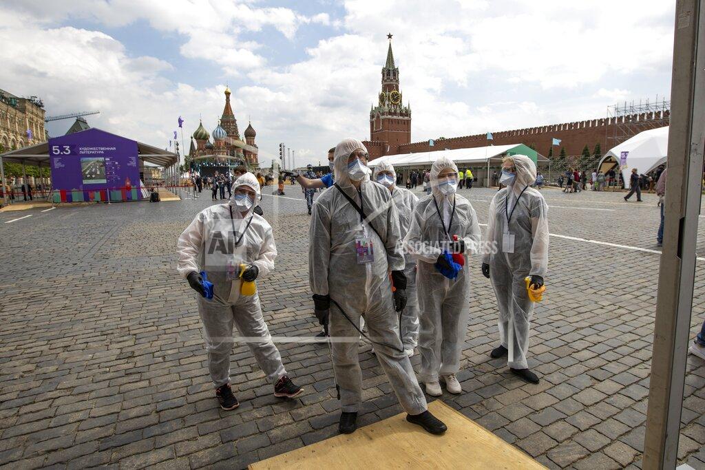 Alexander Zemlianichenko Volunteers wearing face masks, gloves and protective gear to protect against coronavirus, gather to clean an area of an outdoor book market set up at Red Square with GUM, State Department store, left, St. Basil's Cathedral, center, Spasskaya Tower, second with, and the Kremlin Wall, right, in Moscow, Russia, Saturday, June 6, 2020. Muscovites clad in face masks and gloves ventured into Red Square for an outdoor book market, a small sign of the Russian capital's gradual efforts to open up amid coronavirus concerns. (AP Photo/Alexander Zemlianichenko)