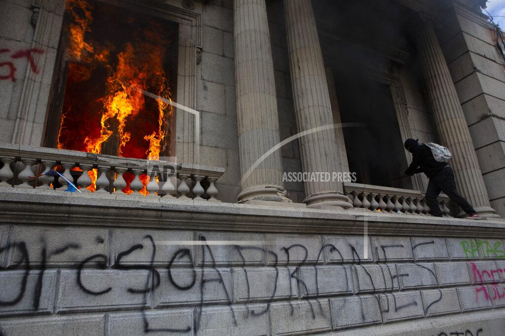 Oliver De Ros Flames shoot out from a corridor of the Congress building after protesters set a part of the building on fire, in Guatemala City, Saturday, Nov. 21, 2020. Hundreds of protesters were protesting in various parts of the country Saturday against Guatemalan President Alejandro Giammattei and members of Congress for the approval of the 2021 budget that reduced funds for education, health and the fight for human rights. (AP Photo/Oliver De Ros)