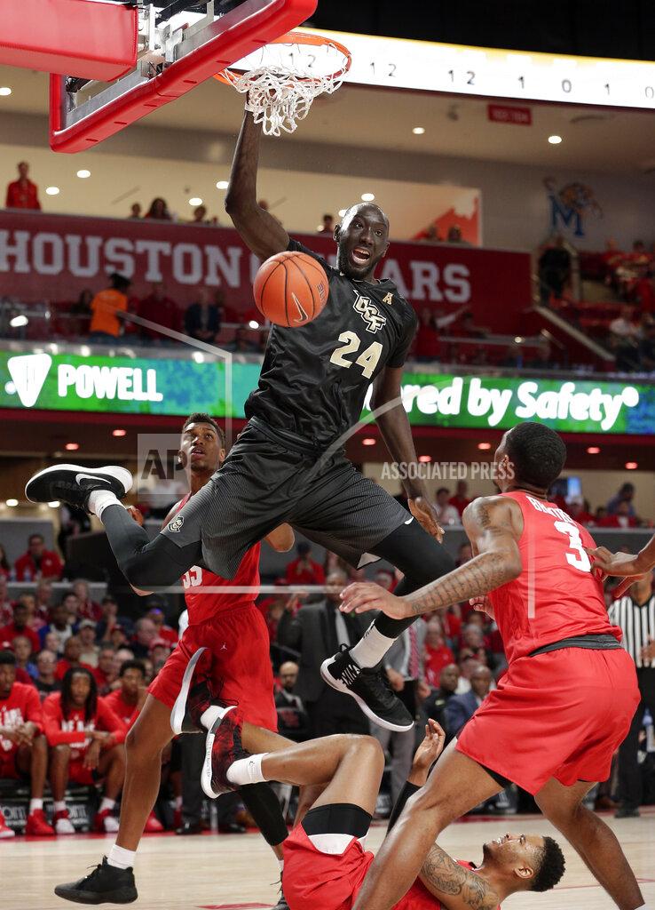 Michael Wyke Central Florida center Tacko Fall (24) dunks over, from left to right, Houston forward Brison Gresham (55), forward Breaon Brady and guard Armoni Brooks (3) during the first half of an NCAA college basketball game Saturday, March 2, 2019, in Houston. (AP Photo/Michael Wyke)