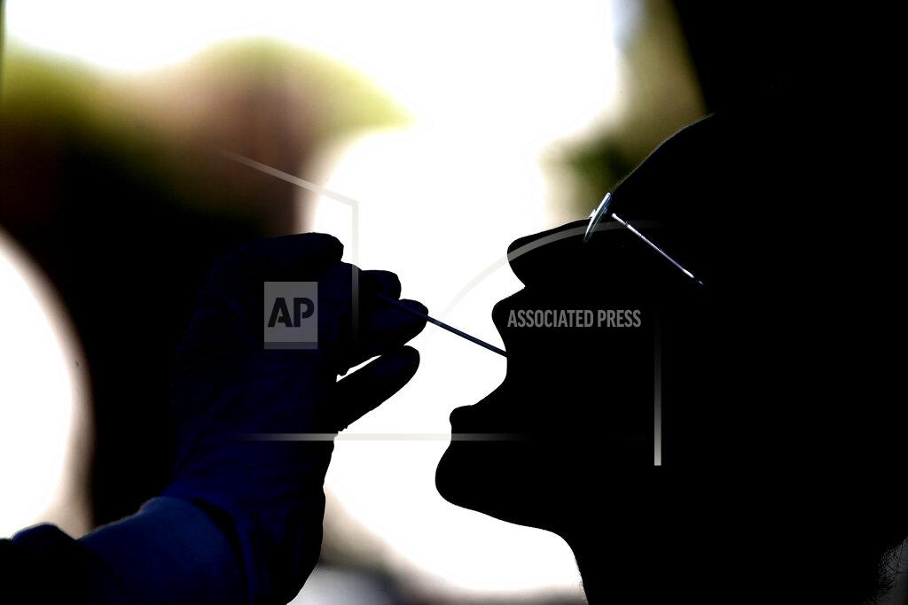 Cecilia Fabiano A woman undergoes testing for COVID-19 at Rome's San Giovanni Addolorata hospital, Friday, Aug. 14, 2020. Italy is imposing mandatory testing on anyone arriving from Greece, Spain, Malta and Croatia as the number of new confirmed cases of coronavirus continues to nudge up with new cases recorded in every region of the country, often imported from abroad. (Cecilia Fabiano/LaPresse via AP)