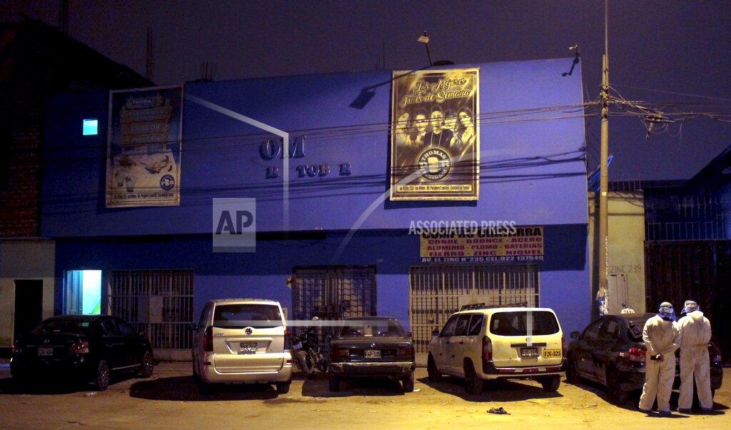 Diego Vertiz Police officers, wearing protective clothing, stand outside a disco in Lima, Peru, Sunday, Aug. 23, 2020. Officials said over a dozen people died in a stampede at the disco after a police raid to enforce the country's lockdown during the coronavirus pandemic. (AP Photo/Diego Vertiz)