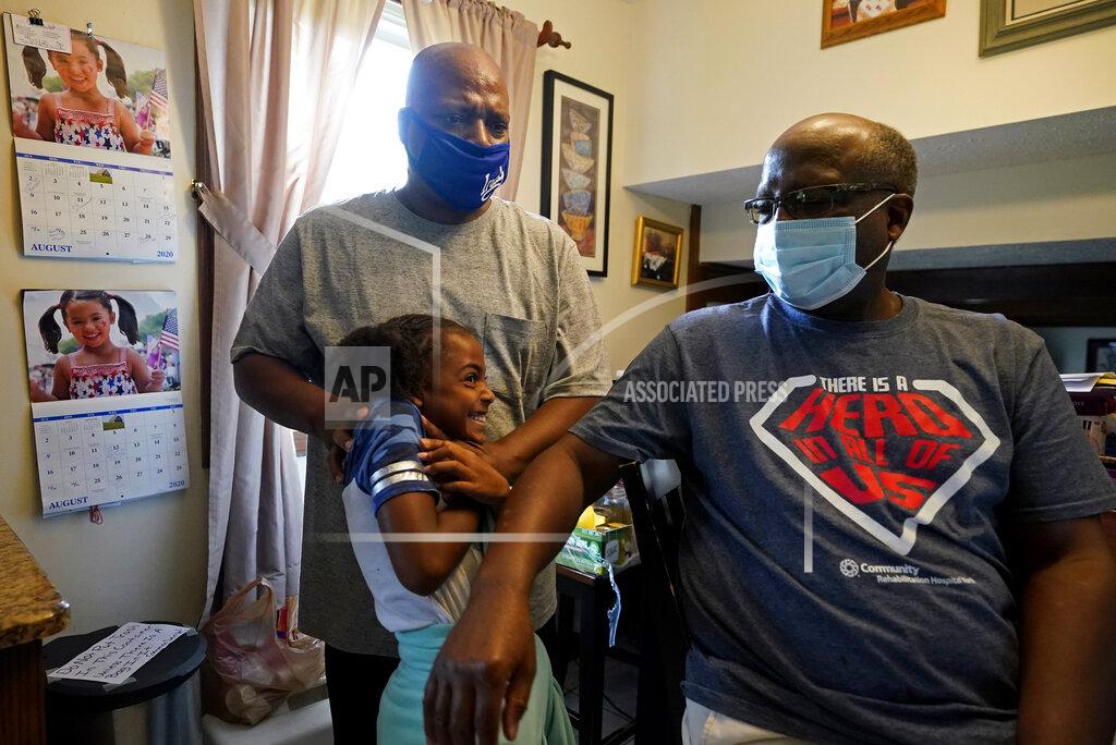 Darron Cummings Larry Brown hugs his daughter, Jabree Glenn, as they talk with Larry's dad, John Brown, Thursday, Aug. 27, 2020, in Indianapolis. (AP Photo/Darron Cummings)