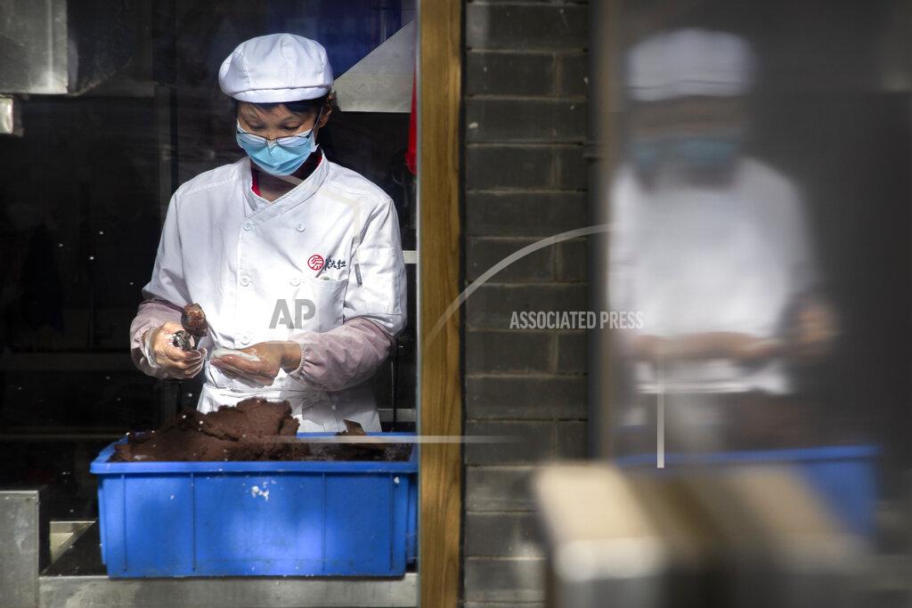Mark Schiefelbein A chef wearing a face mask prepares food at a shop on a pedestrian shopping street in Beijing, Saturday, May 16, 2020. According to official data released on Saturday India's confirmed coronavirus cases have surpassed China's. (AP Photo/Mark Schiefelbein)