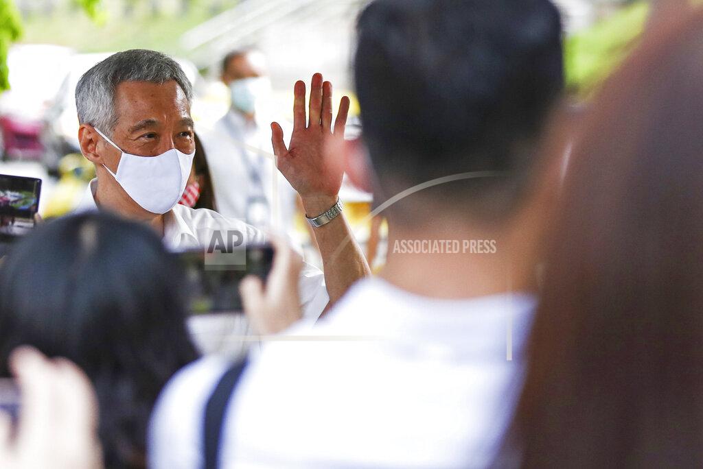 Yong Teck Lim People's Action Party Secretary-General and Singaporean Prime Minister Lee Hsien Loong, left, arrives at a nomination center with his team to submit their nomination papers ahead of the general election in Singapore, Tuesday, June 30, 2020. Campaigning began Tuesday for Singapore's general elections, with the opposition hoping to dent the ruling party's supermajority in parliament with support from Prime Minister Lee's estranged younger brother. (AP Photo/Yong Teck Lim)