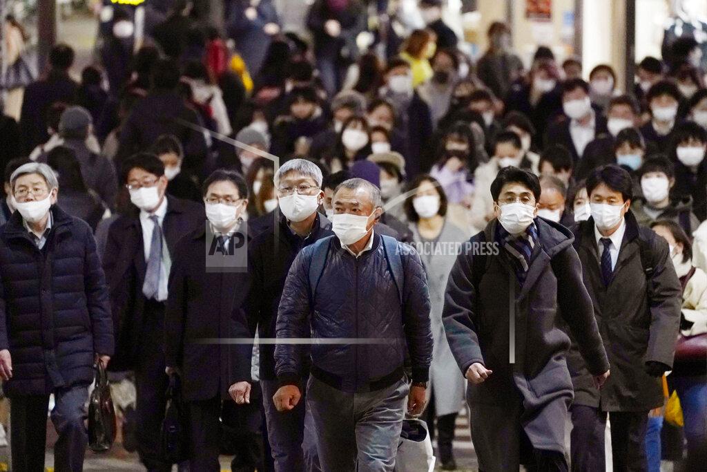 Kenzaburo Fukuhara People wearing face masks to protect against the coronavirus make their way toward a station in Tokyo Monday, Dec. 21, 2020. Daily coronavirus cases have been steadily on the rise nationwide. Tokyo Gov. Yuriko Koike on Monday asked all residents to celebrate Christmas and New Year at home just with their families, and asked organizers to light-up events to close early in the night. (Kenzaburo Fukuhara/Kyodo News via AP)