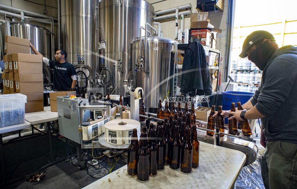 Rick Egan Jordan Vigil and Aaron Buckner bottle beer at Epic Brewing Co. in Salt Lake City, Thursday, Oct. 29, 2020. (Rick Egan/The Salt Lake Tribune via AP)